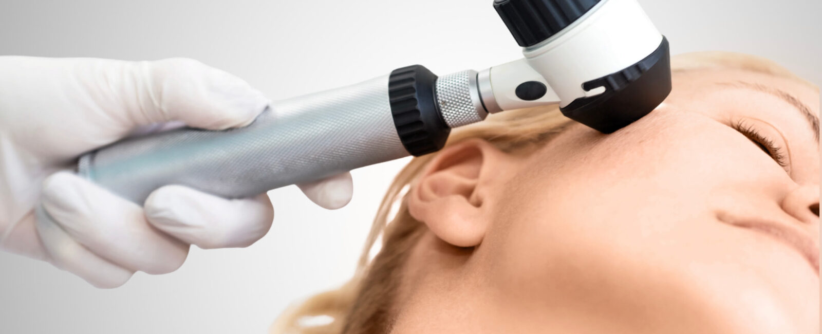 Auf dem Bild ist eine dermatologische Untersuchung zu sehen: Eine Fachärztin oder ein Facharzt betrachtet die Haut im Gesicht einer Patientin mithilfe eines Dermatoskops – einem speziellen Vergrößerungsgerät zur präzisen Beurteilung von Hautveränderungen. Solche Untersuchungen sind essenziell, um eine bakterielle Hauterkrankung frühzeitig zu erkennen und gezielt zu behandeln. Bei Dermacare Wien erfolgt die Diagnose stets unter ärztlicher Aufsicht und mit modernster Technologie, um Entzündungen, Infektionen oder andere Hautprobleme präzise zu bestimmen und individuell zu therapieren.