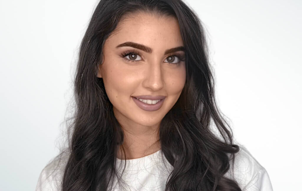 Auf dem Bild ist eine schwarzhaarige Frau zu sehen. Ihr Name ist Rivka und sie ist eine Mitarbeiterin von Dermacare Wien.